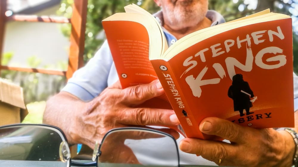 Man Reading Paperback Stephen King Book